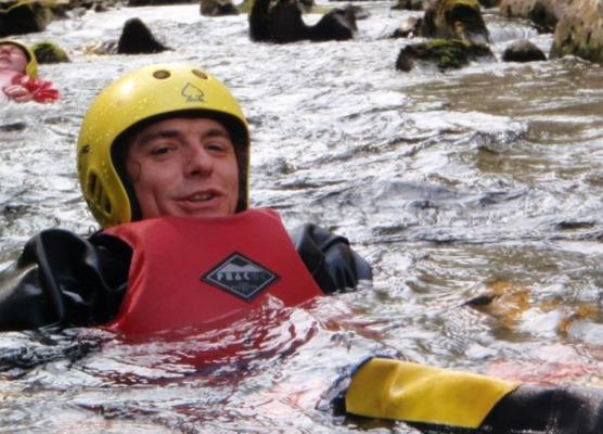 floating on their back in a calm part of the river gorge, while gorge walking