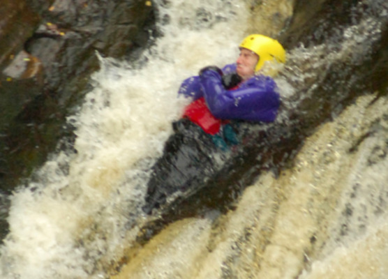 sliding down a waterfall while on a gorge adventure